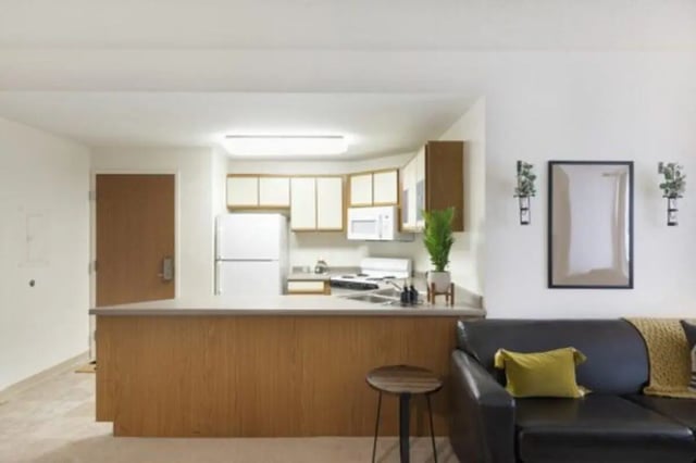 Kitchen area with white fridge and sofa living room at The Quad On Delaware in Minneapolis Student Accommodation
