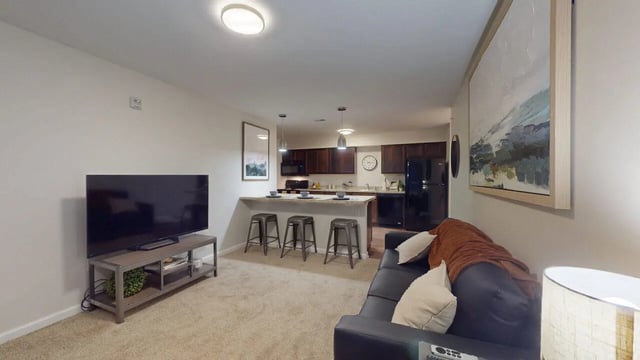 Sofa TV kitchen island and stools living area at Block20