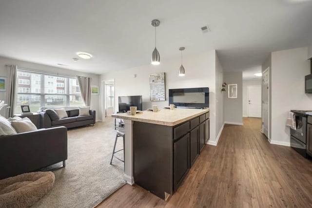 Island kitchen with sofas and TVs living room at Block20