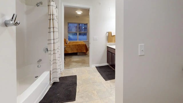Shower tub and doorway to bedroom bathroom at Block20