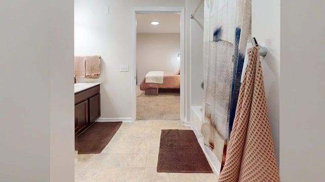 Bathroom with vanity towels shower curtain and bedroom view Bathroom at Block20