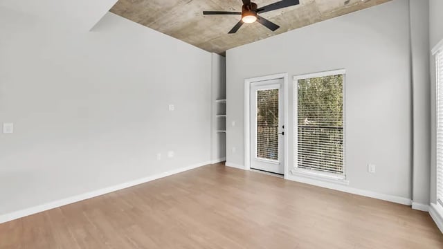 Bare room with ceiling fan windows and shelves living room at The Sinclair in Austin Student Accommodation