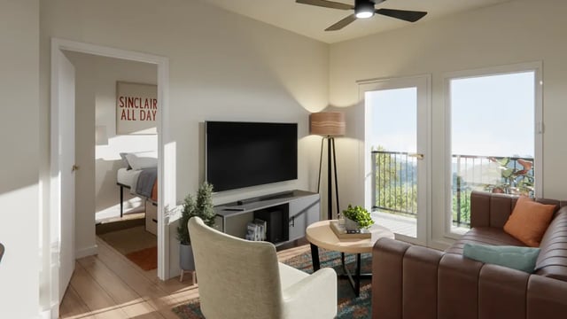 Brown sofa tv and bed visible living room at The Sinclair in Austin Student Accommodation