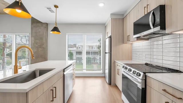 Modern kitchen with island stove and cabinets kitchen at The Sinclair in Austin Student Accommodation