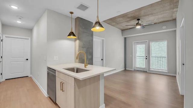 Kitchen island with sink and dishwasher open living area at The Sinclair in Austin Student Accommodation
