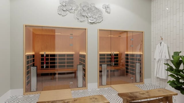 Two glass saunas with wooden benches hanging robe and plant Spa Area at The Sinclair in Austin Student Accommodation