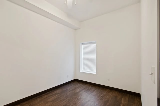 White walls dark wood floor single window bedroom at 800 South in Springfield Student Accommodation