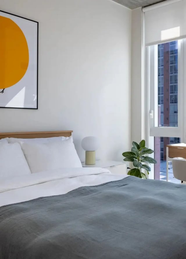 Bed with white linens and grey blanket Bedroom at Straits Row in Chicago Student Accommodation