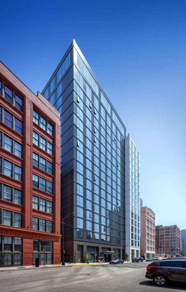 Modern glass building next to red brick building exterior at Straits Row in Chicago Student Accommodation