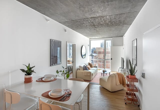 White dining table with place settings and sofa living room at Straits Row in Chicago Student Accommodation