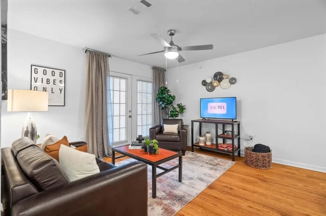 Brown sofas coffee table rug and TV living room at Astoria in Denton Student Accommodation