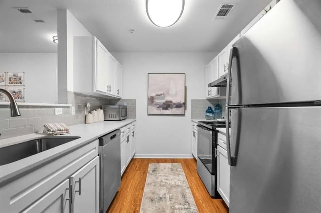 Modern kitchen with stainless steel appliances and white cabinets kitchen at Astoria in Denton Student Accommodation