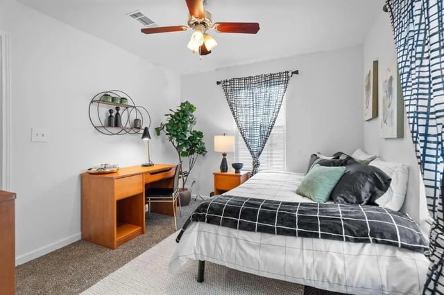 Desk bed plants shelving and ceiling fan bedroom at Astoria in Denton Student Accommodation