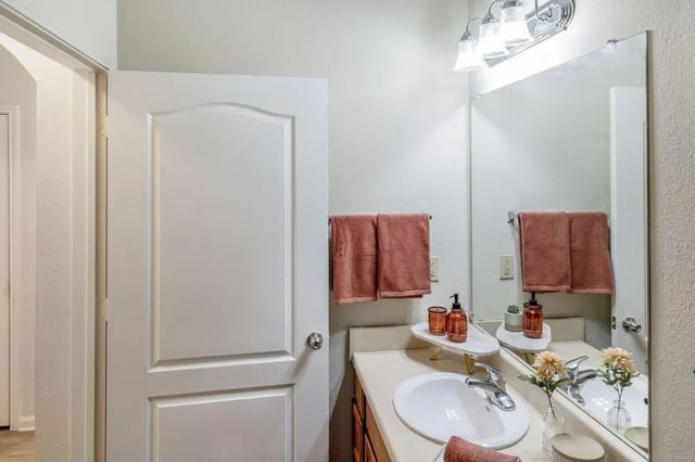 Sink towels vanity mirror with lighting bathroom at The Bluff at Waterworks Landing in Tuscaloosa Student Accommodation