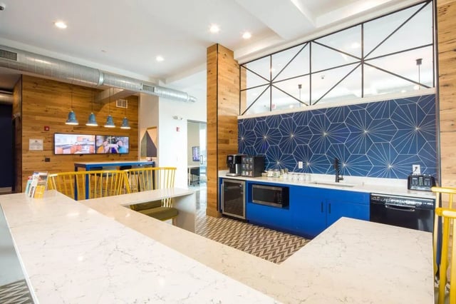 Bar counter with modern kitchen and seating area at The Bluff at Waterworks Landing in Tuscaloosa Student Accommodation