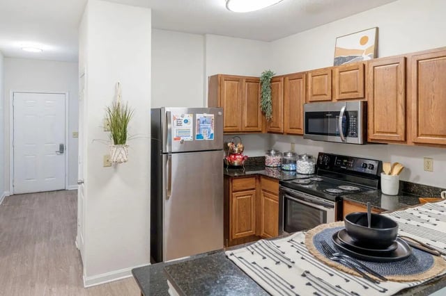 Stainless steel refrigerator wooden cabinets microwave stove kitchen at The Bluff at Waterworks Landing in Tuscaloosa Student Accommodation