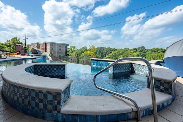 Curved pool edge with metal railing spa area at The Bluff at Waterworks Landing in Tuscaloosa Student Accommodation