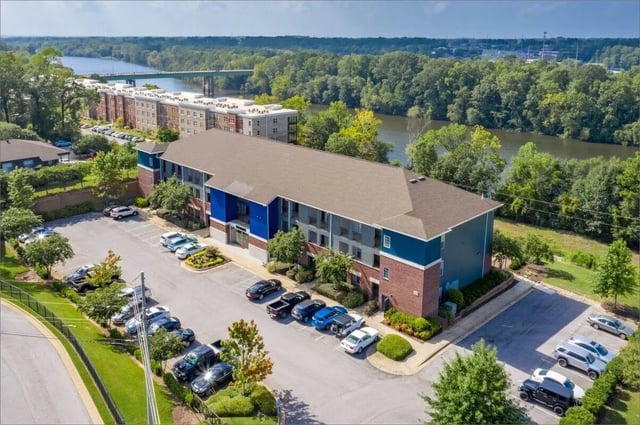 Apartment building with parking lot exterior at The Bluff at Waterworks Landing in Tuscaloosa Student Accommodation