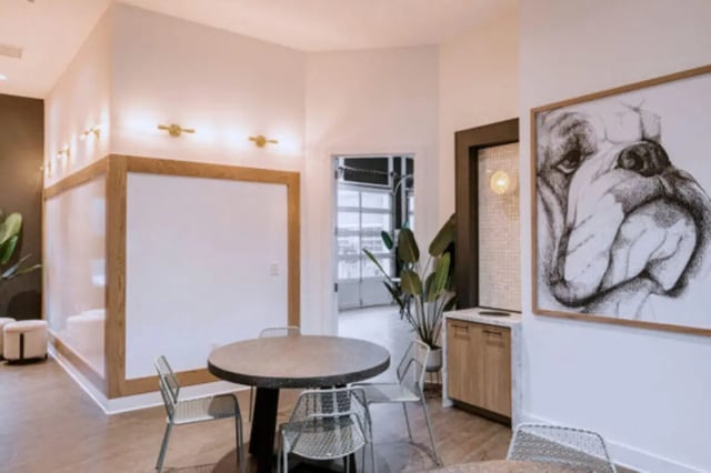 Round table chairs framed dog art common area living room at Athens Ridge in Athens Student Accommodation