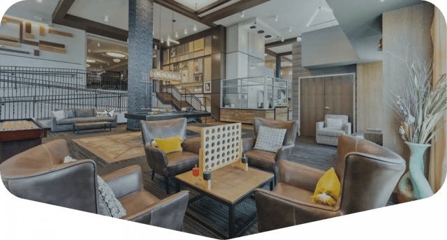 Leather armchairs connect four table shuffleboard living room at The Valley Apartments & Townhomes in State College Student Accommodation