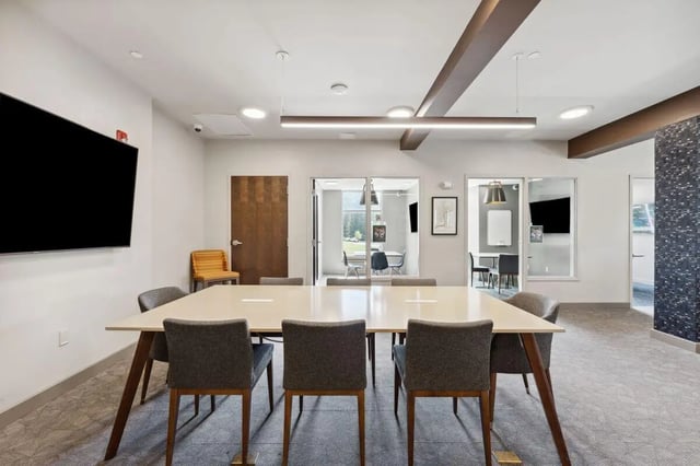 Table with chairs and large TV study area at The Valley Apartments & Townhomes in State College Student Accommodation