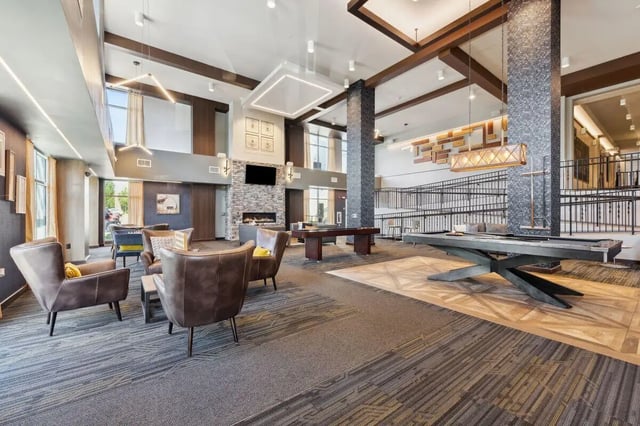 Lounge chairs fireplace pool table billiards area at The Valley Apartments & Townhomes in State College Student Accommodation