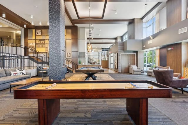 Shuffleboard pool tables couch lounge area living room at The Valley Apartments & Townhomes in State College Student Accommodation
