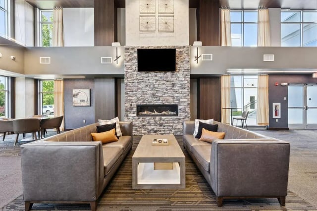 Two sofas fireplace and coffee table common area at The Valley Apartments & Townhomes in State College Student Accommodation