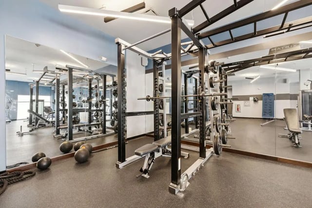 Weight racks benches dumbbells mirrors gym at The Valley Apartments & Townhomes in State College Student Accommodation