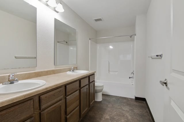 Two sinks toilet bathtub white shower bathroom at The Jefferson Apartments in Springfield Student Accommodation