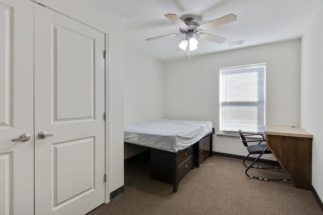 Bed desk chair and closet bedroom at The Jefferson Apartments in Springfield Student Accommodation
