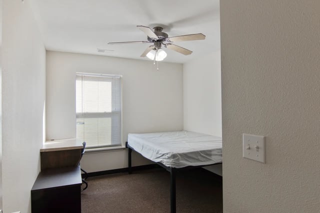 Bed desk ceiling fan window bedroom at The Jefferson Apartments in Springfield Student Accommodation