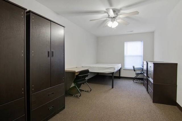 Dark wardrobes bed desk chair dressers bedroom at The Jefferson Apartments in Springfield Student Accommodation