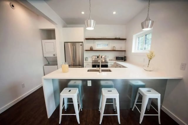 Modern kitchen with stainless steel appliances and stools kitchen at Campus Prime in Syracuse Student Accommodation