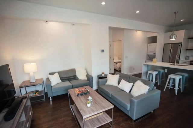 Two grey sofas coffee table kitchen living room at Campus Prime in Syracuse Student Accommodation