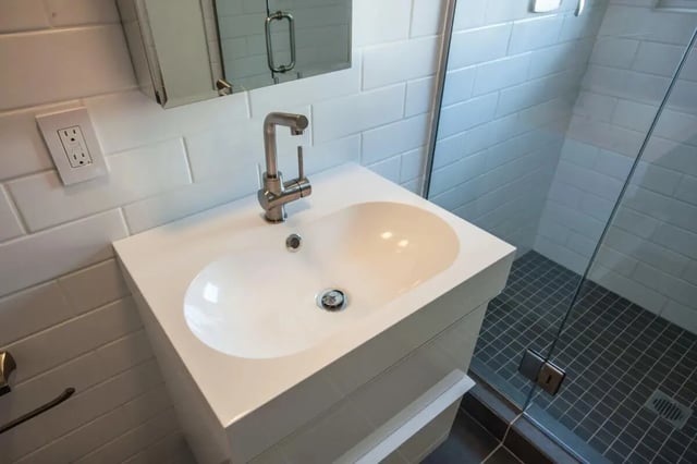 White vanity sink and tiled shower stall bathroom at Campus Prime in Syracuse Student Accommodation