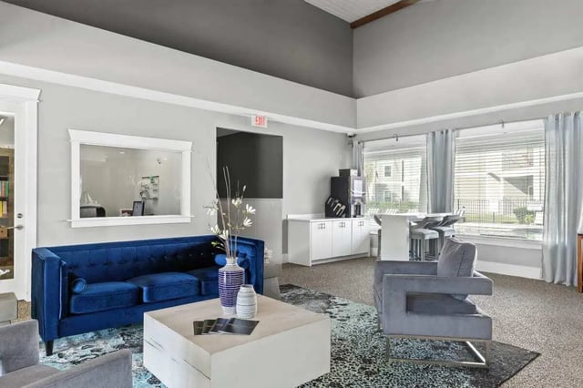 Blue sofa grey armchair coffee table lounge area at Campus Quarters in Corpus Christi Student Accommodation