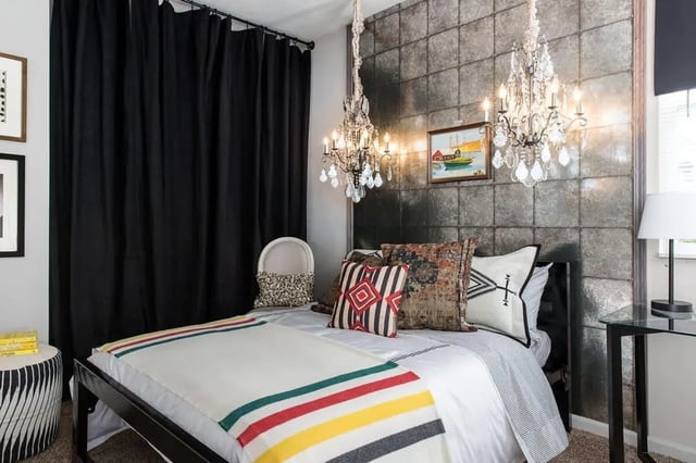 Bed with striped blanket and pillows chandelier bedroom at Campus Quarters in Corpus Christi Student Accommodation
