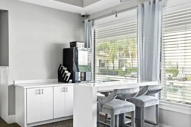 Coffee machine white cabinets bar stools outdoor view area at Campus Quarters in Corpus Christi Student Accommodation