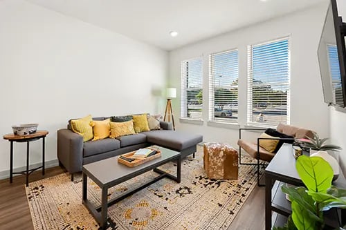 Gray sectional couch with colorful pillows coffee table living room at The Jolly Roger in Greenville Student Accommodation