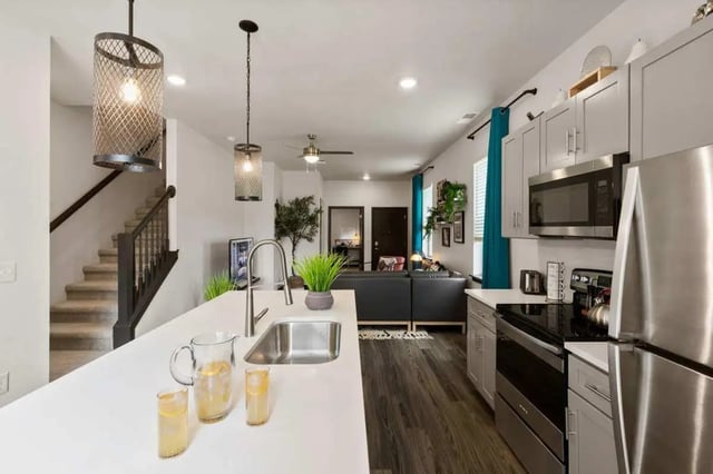 Kitchen with sink counter and living area living room at Atlas on 17th in Bloomington Student Accommodation