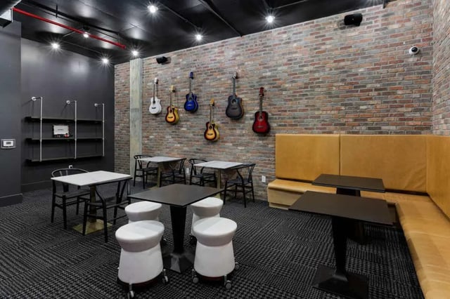 Guitars tables stools and booth lounge area at Atlas on 17th in Bloomington Student Accommodation