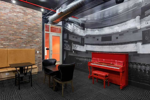 Seating area with piano and theater mural Living room at Atlas on 17th in Bloomington Student Accommodation