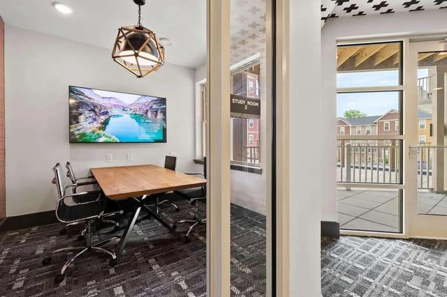 Conference table chairs and TV study room at Atlas on 17th in Bloomington Student Accommodation