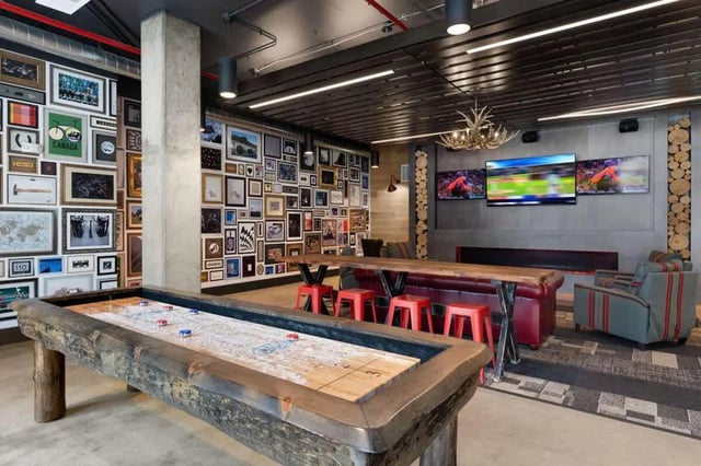 Shuffleboard table red stools TVs common area at Atlas on 17th in Bloomington Student Accommodation