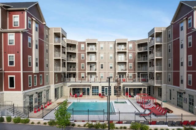 Apartment buildings surrounding courtyard pool and lounge chairs exterior at Atlas on 17th in Bloomington Student Accommodation