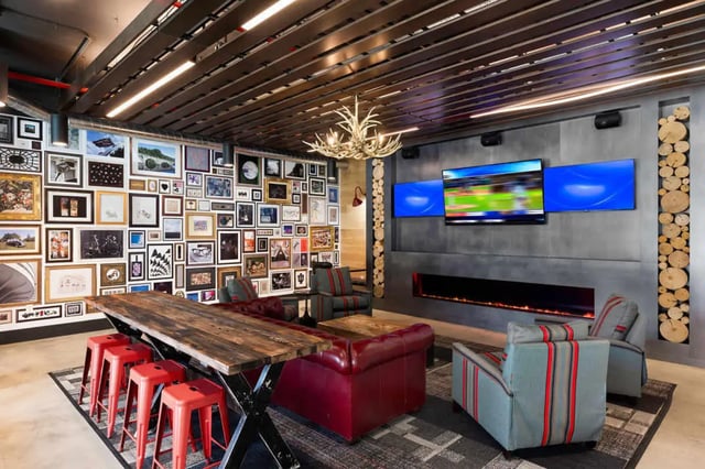 Gallery wall fireplace three TVs and seating living room at Atlas on 17th in Bloomington Student Accommodation