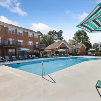 Pool loungers umbrellas apartments building exterior at Eighteen18 at Southern in Statesboro Student Accommodation