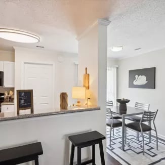 Bar stools kitchen counter and dining table living room at Eighteen18 at Southern in Statesboro Student Accommodation