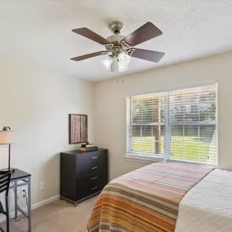 Bed dresser desk and ceiling fan bedroom at Eighteen18 at Southern in Statesboro Student Accommodation